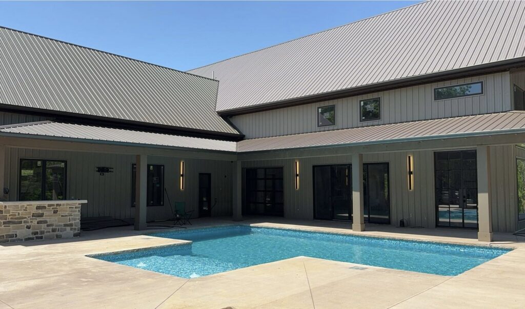 An L-shaped inground pool with light blue water and concrete patio, expertly installed by Riverstone LLC in Bowling Green, KY.