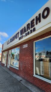 The storefront of LACarpetWarehouse in Los Angeles, CA, showing the business name and address.