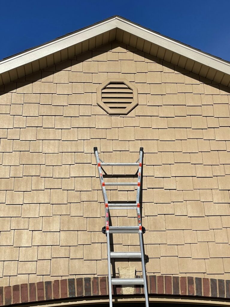A ladder positioned at a house gable vent, indicating wildlife exclusion work by Prairie Bat Services, LLC in Sioux Falls, SD.