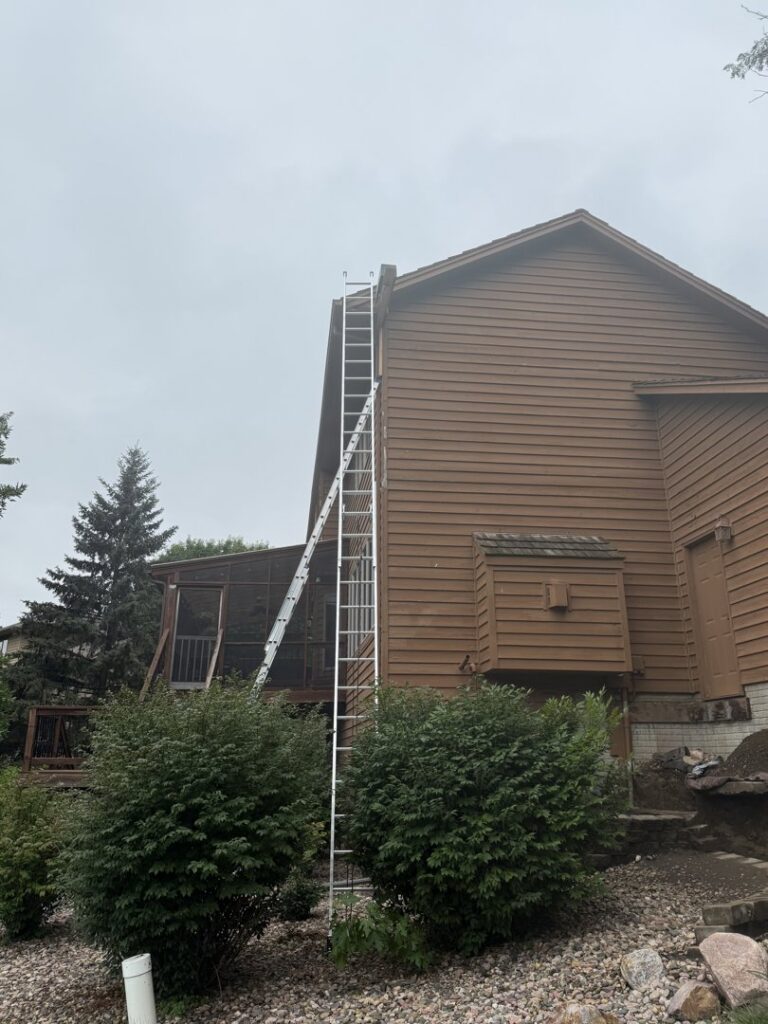A ladder leaning against a house exterior, set up for bat exclusion or wildlife inspection by Prairie Bat Services, LLC in Sioux Falls, SD.