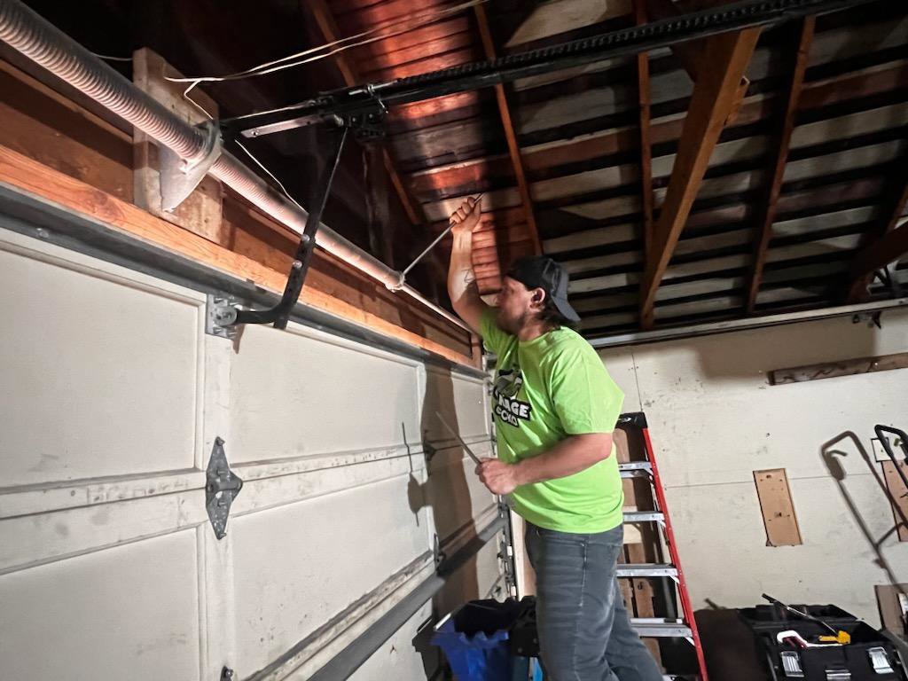 A ladder set up inside a garage, with a Garage Gecko service truck outside, indicating work in progress in Spokane, WA.