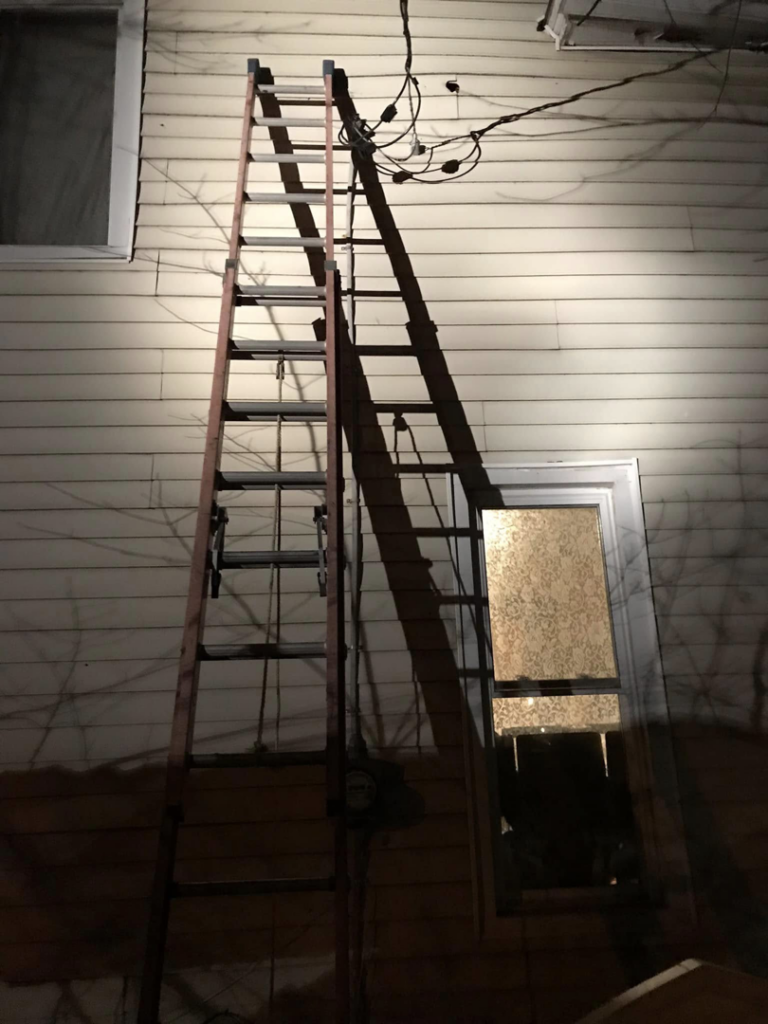 A ladder leaning against a house at night, indicating residential electrical service repair by DRS Electric Co. in Erie, PA.