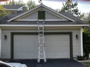 A ladder positioned for attic vent inspection or exclusion work on a residential garage by Stellar Wildlife Solutions in Cottage Grove, MN.