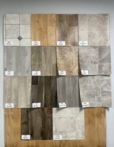 A display board showcasing various laminate and vinyl flooring samples at Sy's Discount Carpets in Los Angeles, CA