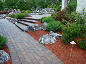 A professionally designed landscape with a paved walkway, steps, and mulched beds by Kustom Lawn Kare LLC in Greenwood, IN.