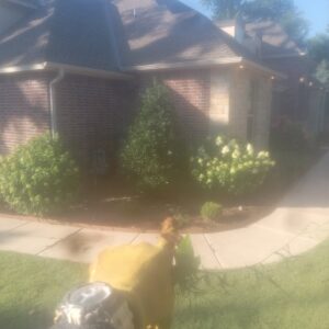 A completed landscape design with fresh mulch and new plants next to a house by A & A Lawn Care Service LLC in Moore, OK.