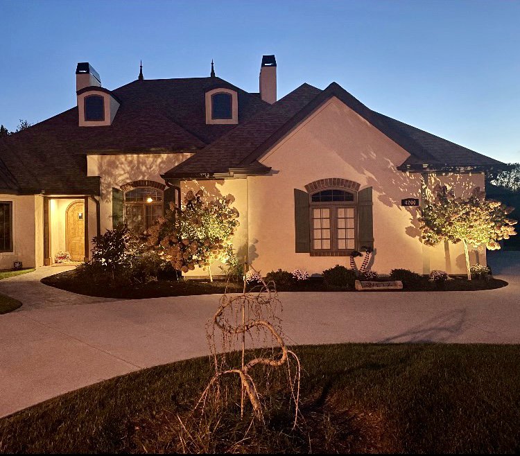 Landscape lighting illuminating a house exterior at dusk by Pinnacle Electric Solutions in Port St. Lucie, FL.
