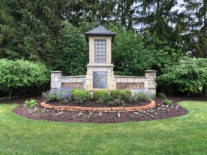 A beautifully landscaped entrance sign with flowers and shrubs, maintained by Roots Lawn Care Solutions in Granger, IN.