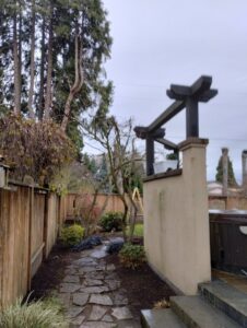 A landscaped side yard with a stone path and mulched beds, maintained by Tony's Lawn Care Services in Greenville, SC.