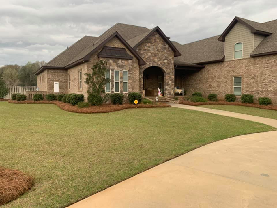 Beautiful landscaping with pine straw beds and a neatly mowed lawn by NewLeaf Lawn Care LLC in Dothan, AL.