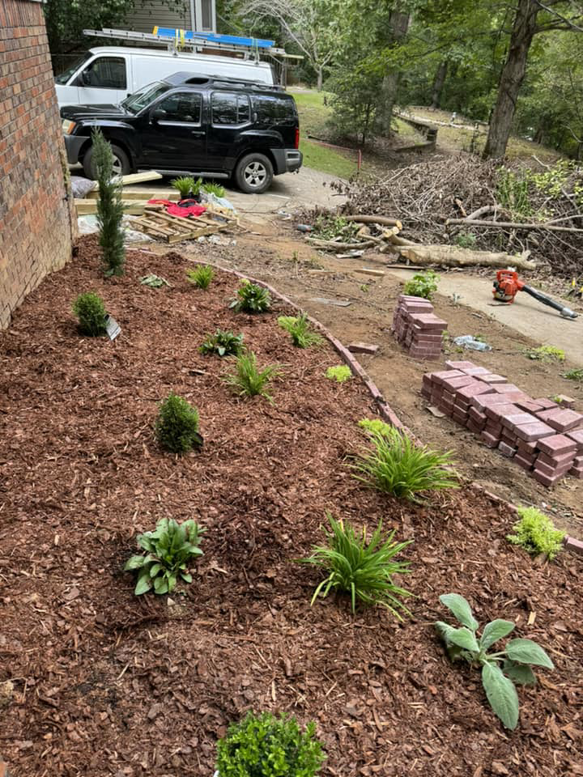 Landscaping work in progress with new plants, mulch, and tools by D&L lawn care service in Hoover, AL