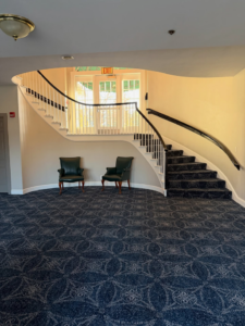 Expansive blue patterned wall-to-wall carpet installed on a floor and matching staircase by Persian Rug Gallery in Nashua, NH.