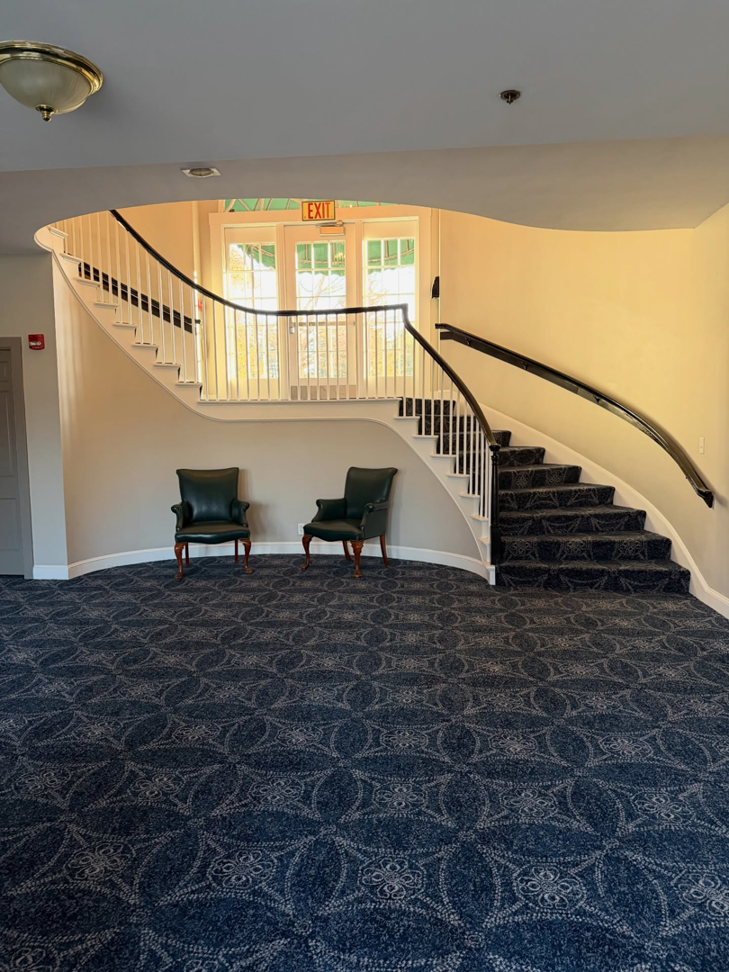 Expansive blue patterned wall-to-wall carpet installed on a floor and matching staircase by Persian Rug Gallery in Nashua, NH.