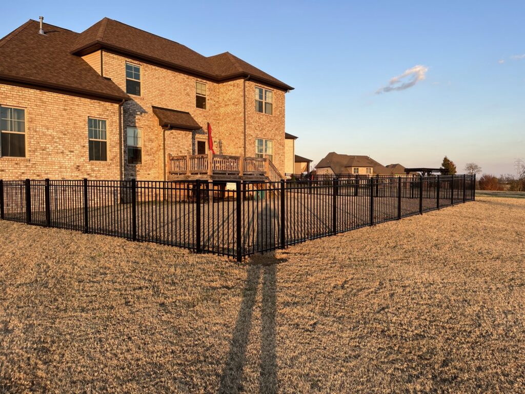 A large backyard enclosed with a black aluminum fence installed by Frontier Fence LLC Bowling Green,Ky