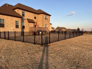 A large backyard enclosed with a black aluminum fence installed by Frontier Fence LLC Bowling Green,Ky
