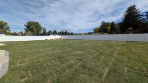 A large backyard enclosed by a white vinyl privacy fence installed by 208 Fence and Gate in Idaho Falls, ID.