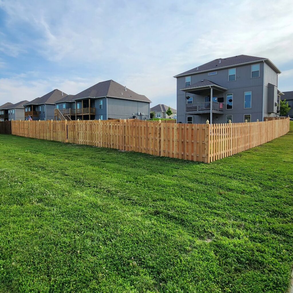 A large backyard enclosed by a beautiful wood picket fence, installed by Hotshot Fencing and Gates in Kansas City, MO.
