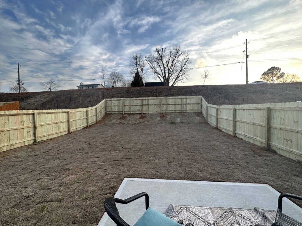 A large backyard enclosed by a newly installed wood privacy fence by Right Now Fencing, LLC in Johns Creek, GA