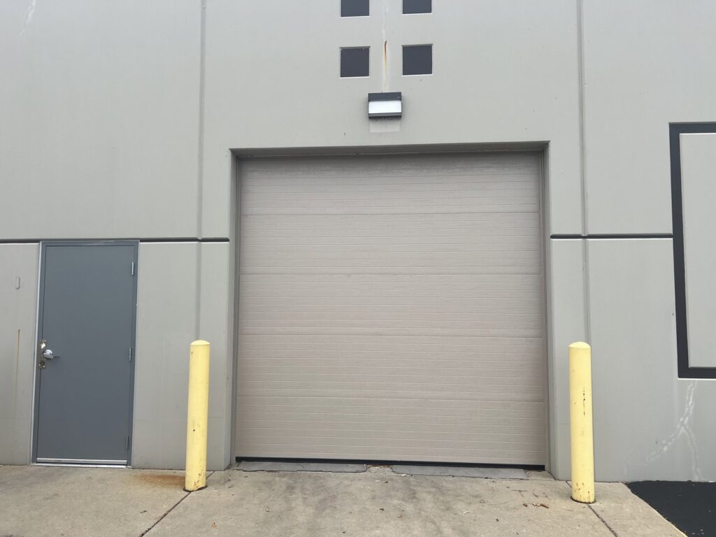 A large beige commercial roll-up garage door, a completed project by McDonald Overhead Door Inc. in Kenosha, WI.