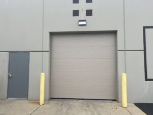 A large beige commercial roll-up garage door, a completed project by McDonald Overhead Door Inc. in Kenosha, WI.
