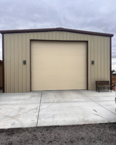 Large beige sectional garage door on a metal building installed by Mr. Garage Door in Bell Gardens, CA.