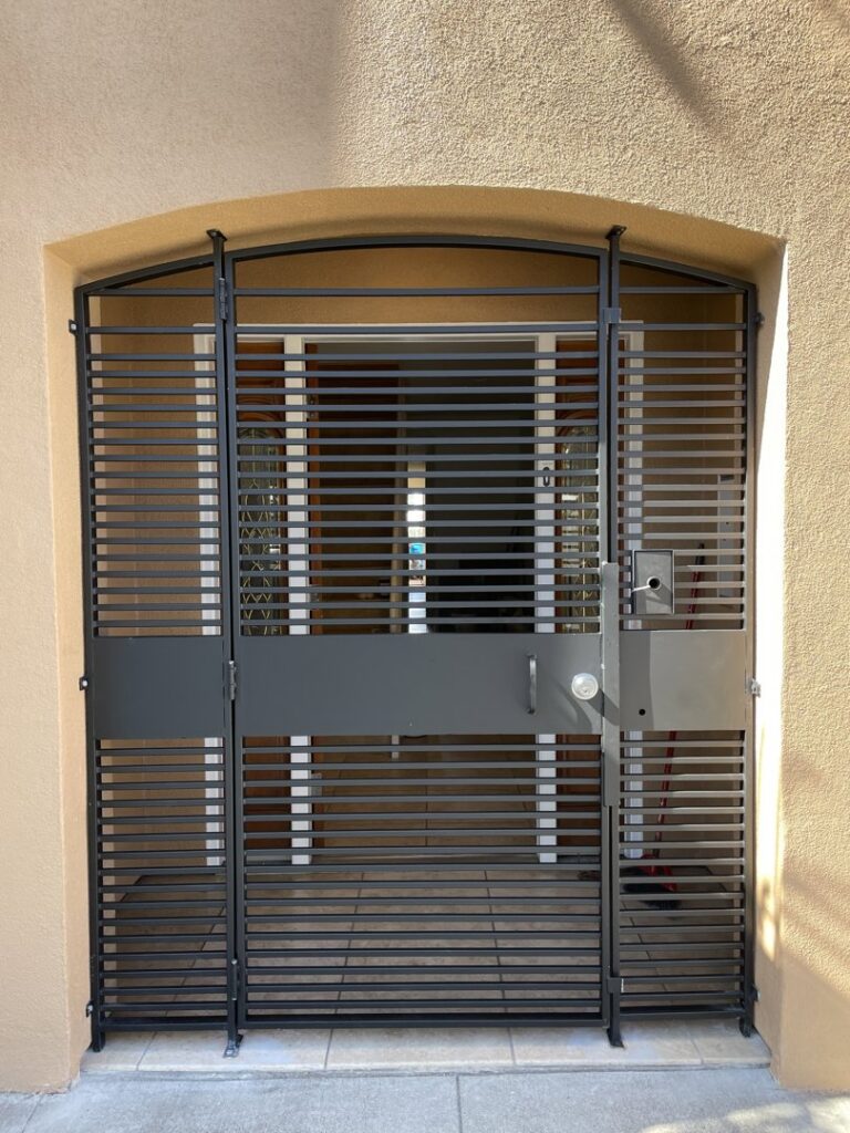 A large black metal security gate with horizontal bars installed in an arched entryway by Fierro Iron Works Inc. in San Francisco, CA.