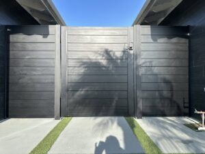 A large black horizontal slat driveway gate installed by No Limit Fence Company in Huntington Beach, CA.