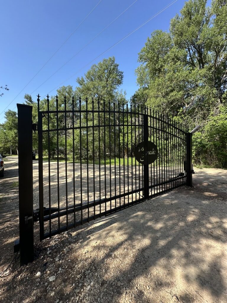 A large black wrought iron gate with custom lettering, expertly installed by Stand Strong Fencing of East Austin, TX.