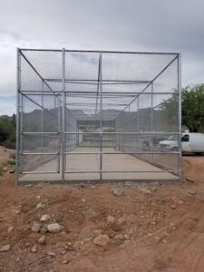 A large, custom-built chain-link enclosure or cage constructed by SFA Contracting LLC in Tucson, AZ.