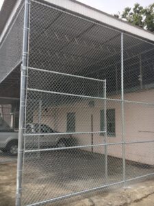 A large chain-link fence enclosure installed for a commercial or industrial property by Pride Fence LLC in Overland Park, KS.