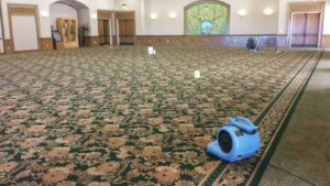 A large commercial room with patterned carpet being cleaned and dried with an air mover by Oahu Carpet Cleaning Co. in Honolulu, HI.