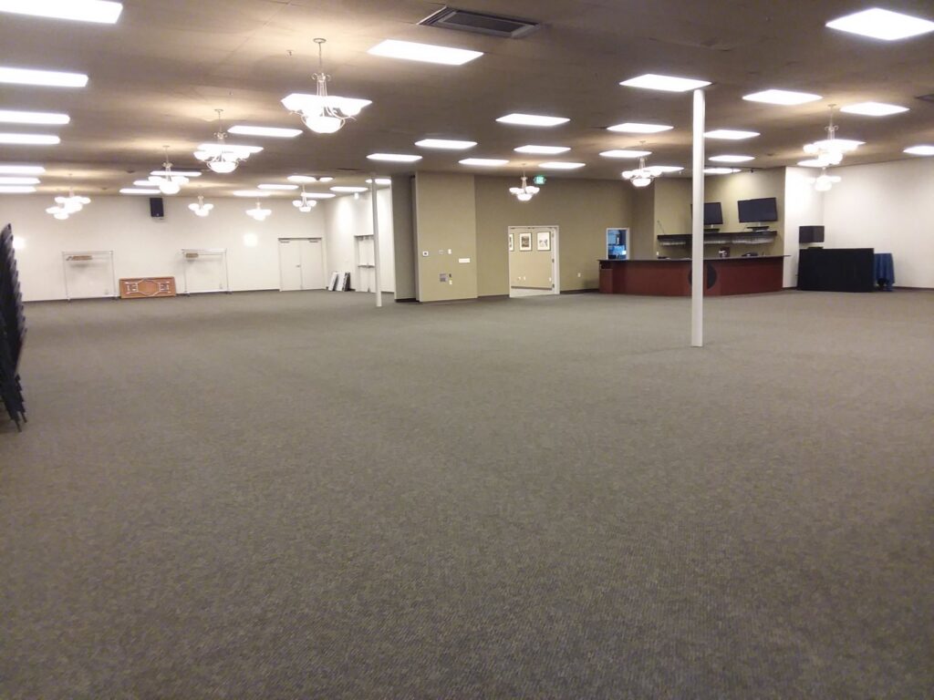 A spacious commercial room with clean grey carpet, serviced by JR Professional Carpet Cleaning Business LLC in Spokane, WA.
