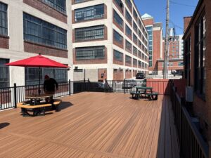 A large commercial-style deck with black railings and picnic tables, constructed by Chesley Fence & Deck in Fairview Heights, IL.