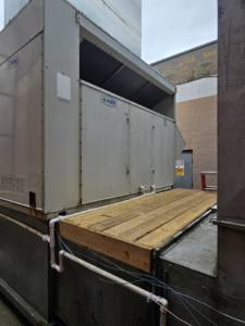 A large commercial HVAC system with a wooden access platform, maintained by Capitol Heating and Air in Morgantown, PA.