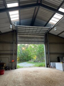 A large commercial overhead door, partially open, showing an installation or repair by Northern Door Company in Saint Paul, MN
