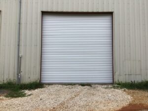 A large commercial roll-up garage door on a metal building, installed by Precision Garage Door Service of Mobile in Mobile, AL.