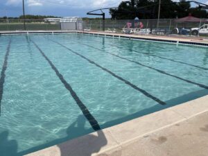 A large, clean community lap pool with lane lines, showcasing work by I10 Pool Plastering LLC in Kenner, LA.