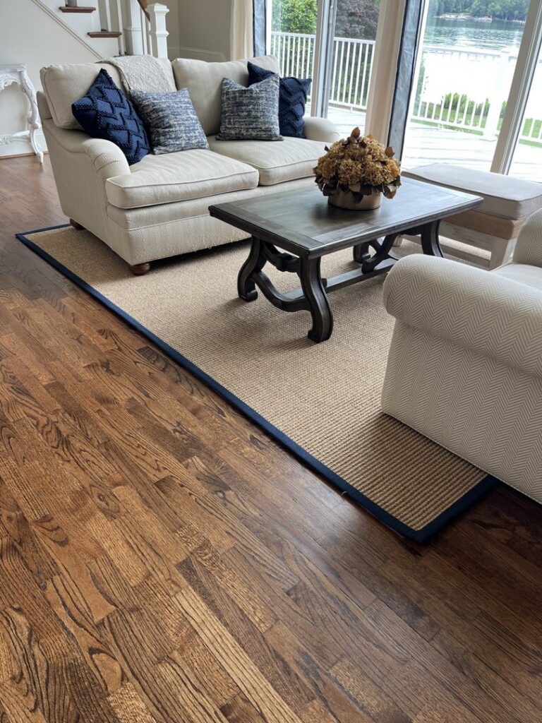 A large custom-bound area rug with a blue border in a living room by Carpet Binding Company in Charlotte, NC.