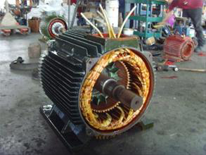 A large electric motor with exposed rotor and stator windings, indicating repair or maintenance services by Alexco Max Electricals And Construction in Madina, GH.