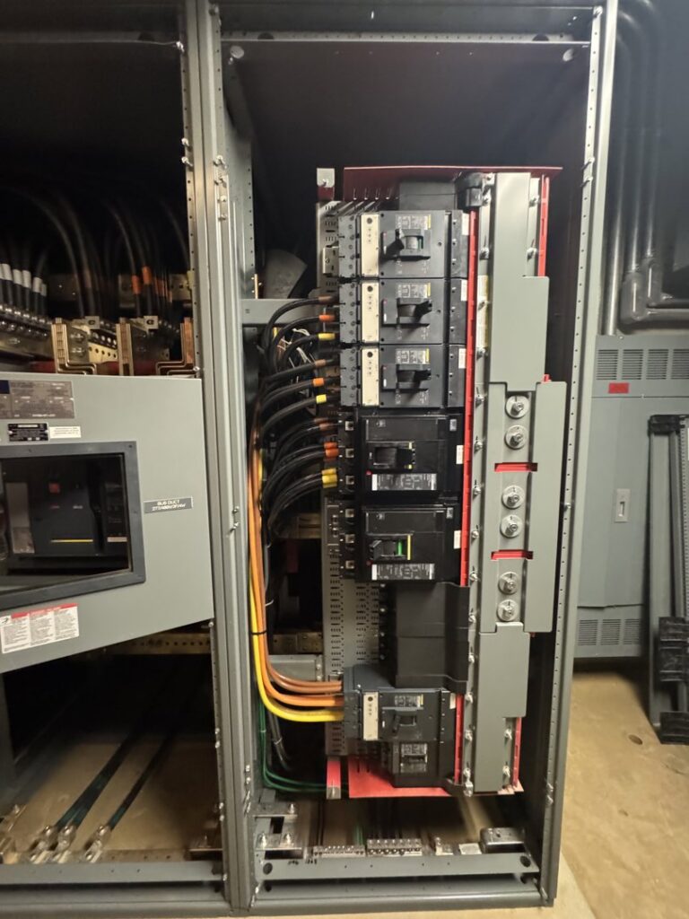 A large electrical switchgear or distribution panel with numerous circuit breakers and intricate wiring, installed by Mend Electric LLC in Fort Worth, TX.