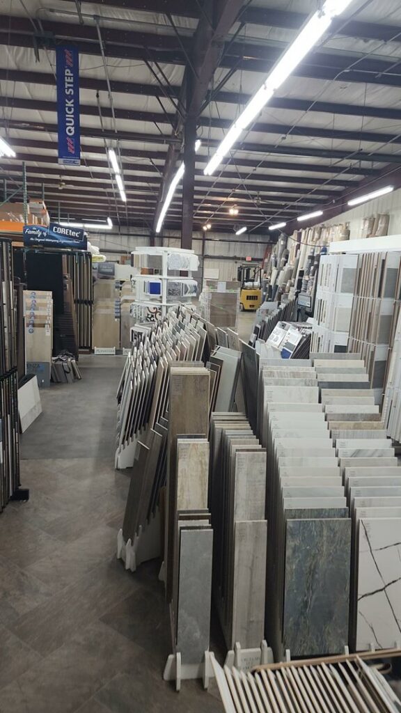 A large warehouse filled with various flooring materials and tile inventory at CarpetsPlus Colortile in Swansea, MA