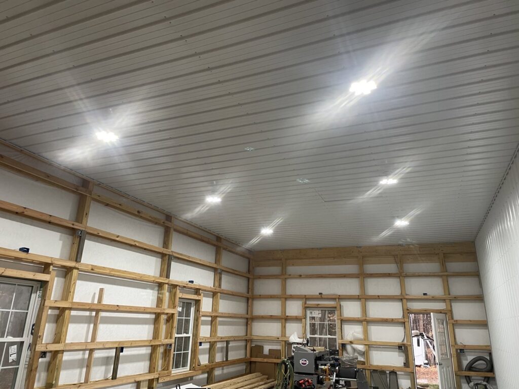 Large garage or workshop with multiple bright LED panel lights installed on the ceiling by CLB Electrical LLC in Townsend, DE.