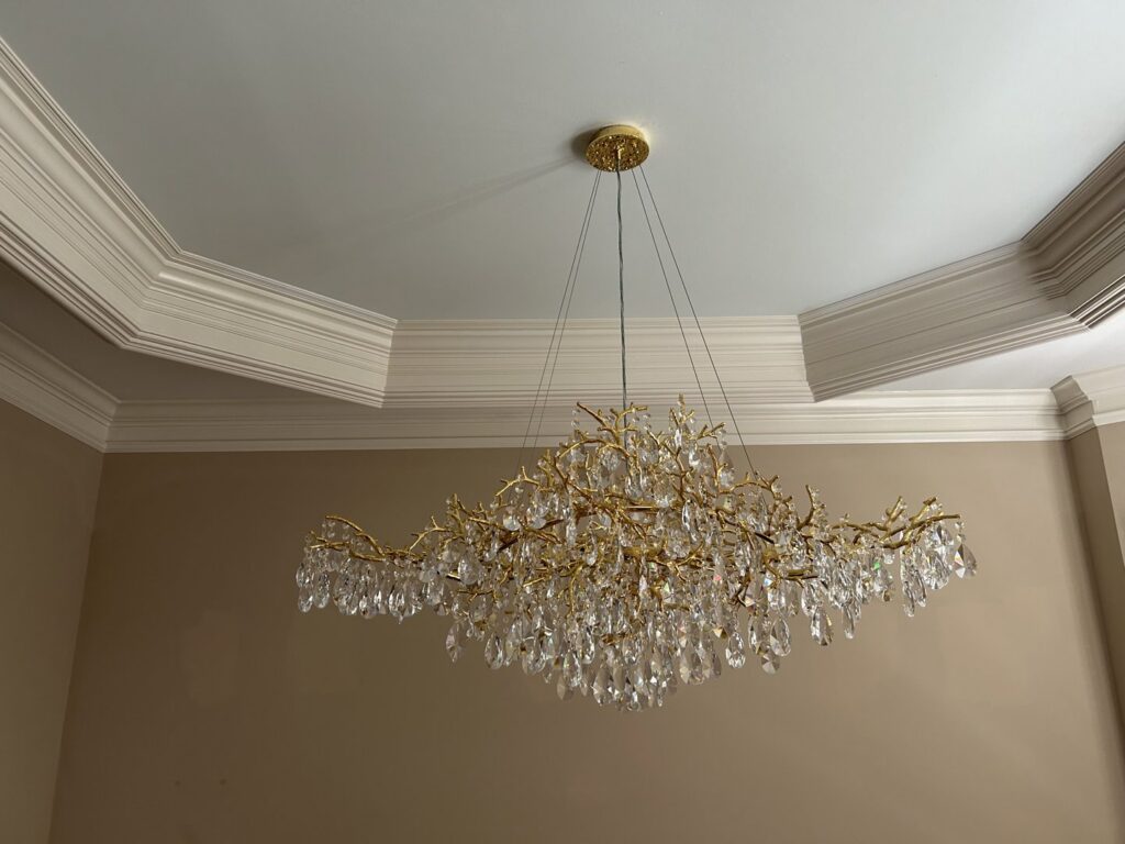 Installation of a large, elegant gold branch chandelier with crystal drops by Perfection Lighting, Design, and Installations in Atlanta, GA.