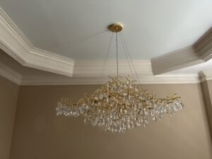 Installation of a large, elegant gold branch chandelier with crystal drops by Perfection Lighting, Design, and Installations in Atlanta, GA.
