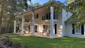 A large, elegant home featuring a perfectly manicured green lawn and landscaping by Total Lawn in Lawrence, KS