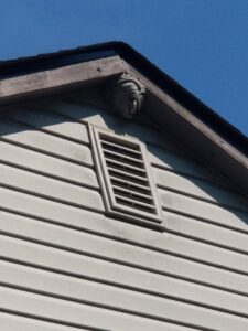 A large hornet's nest visible under the eaves of a house, requiring pest control services from Stryker Pest Control LLC in Columbus, OH.