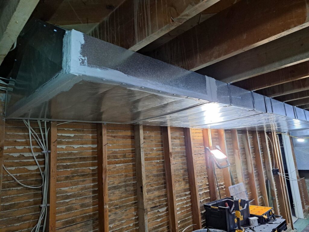 Large rectangular HVAC ductwork being installed in a ceiling or wall cavity by ABC Mechanical Inc in Lawrenceville, GA.