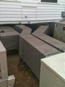 Large metal HVAC ductwork installed underneath a building by R&B Cooling&Heating in Abbeville, LA.