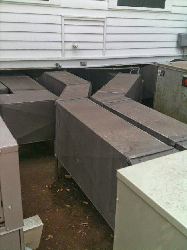 Large metal HVAC ductwork installed underneath a building by R&B Cooling&Heating in Abbeville, LA.