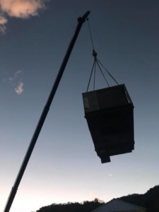 A large HVAC unit being lifted by a crane during an installation or replacement project by R & R H.V.A.C in Knoxville, TN.